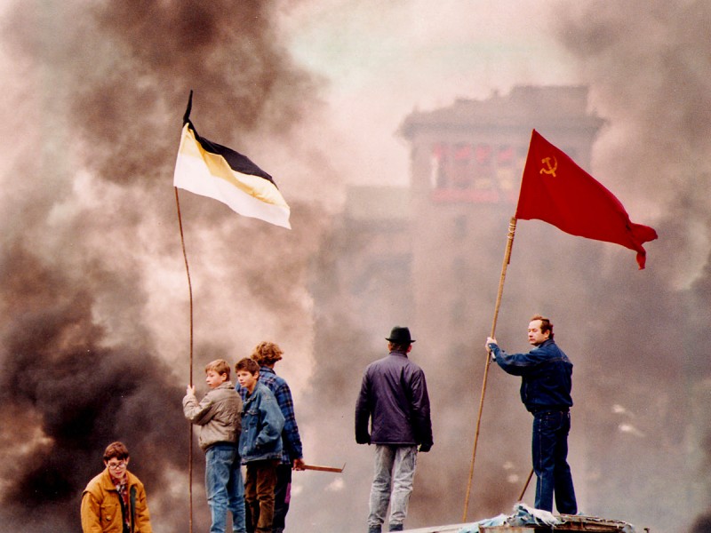 MOSCOW RIOTS: Hard-line demonstrators raise the flag of the Liberal Democratic Party (l) and the former Soviet flag while smoke from burning barricades billows in a main street of downtown Moscow, Saturday, Oct. 02, 1993. Several hundred hard-liners clashed with riot police. (AP-Photo/stf/Peter Deong)